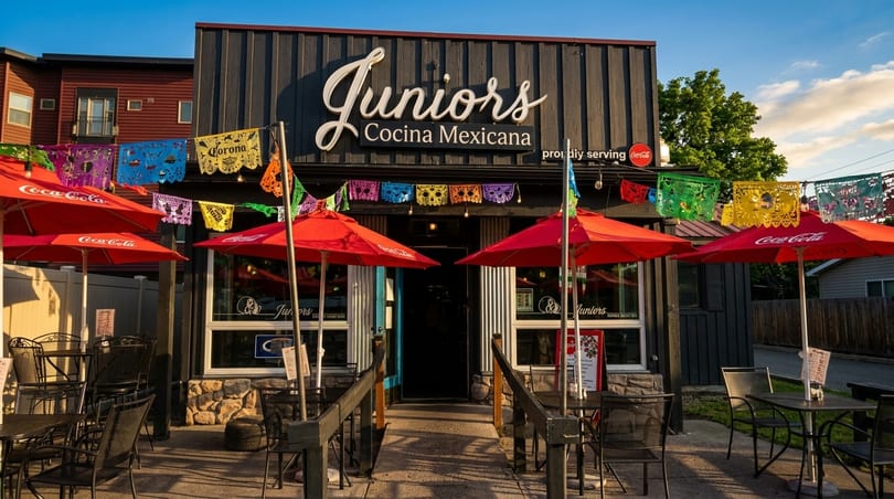 Juniors Cocina Mexicana restaurant exterior with red umbrellas, outdoor seating, and colorful papel picado.